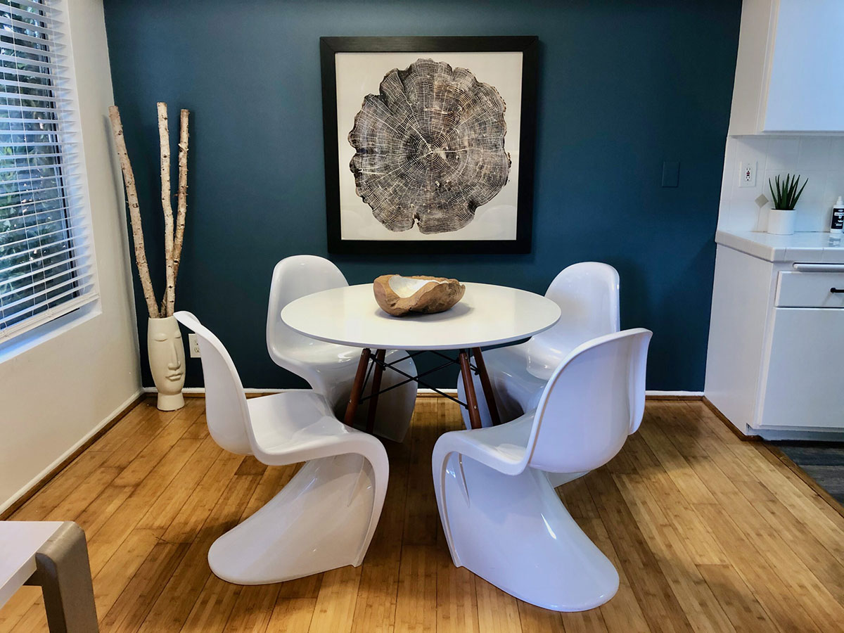 Dining area with white round table and retro futuristic chairs.