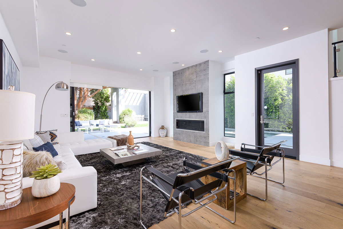 Living room near pool with sofa, television and rug.