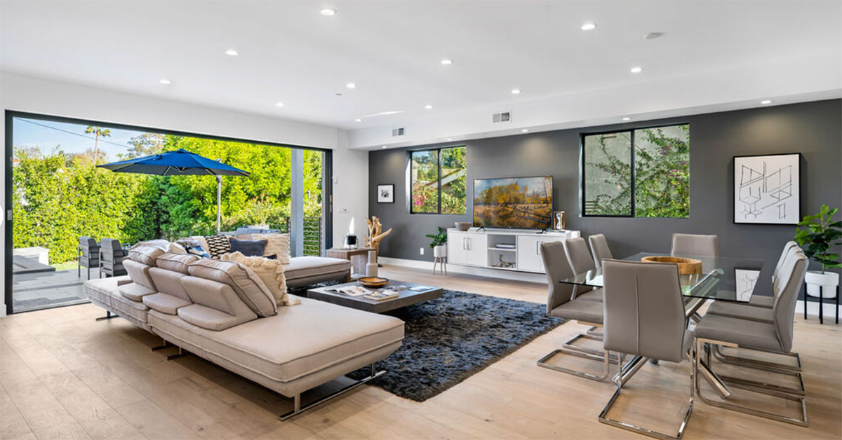 Living room near patio with sofa, television and dining table.