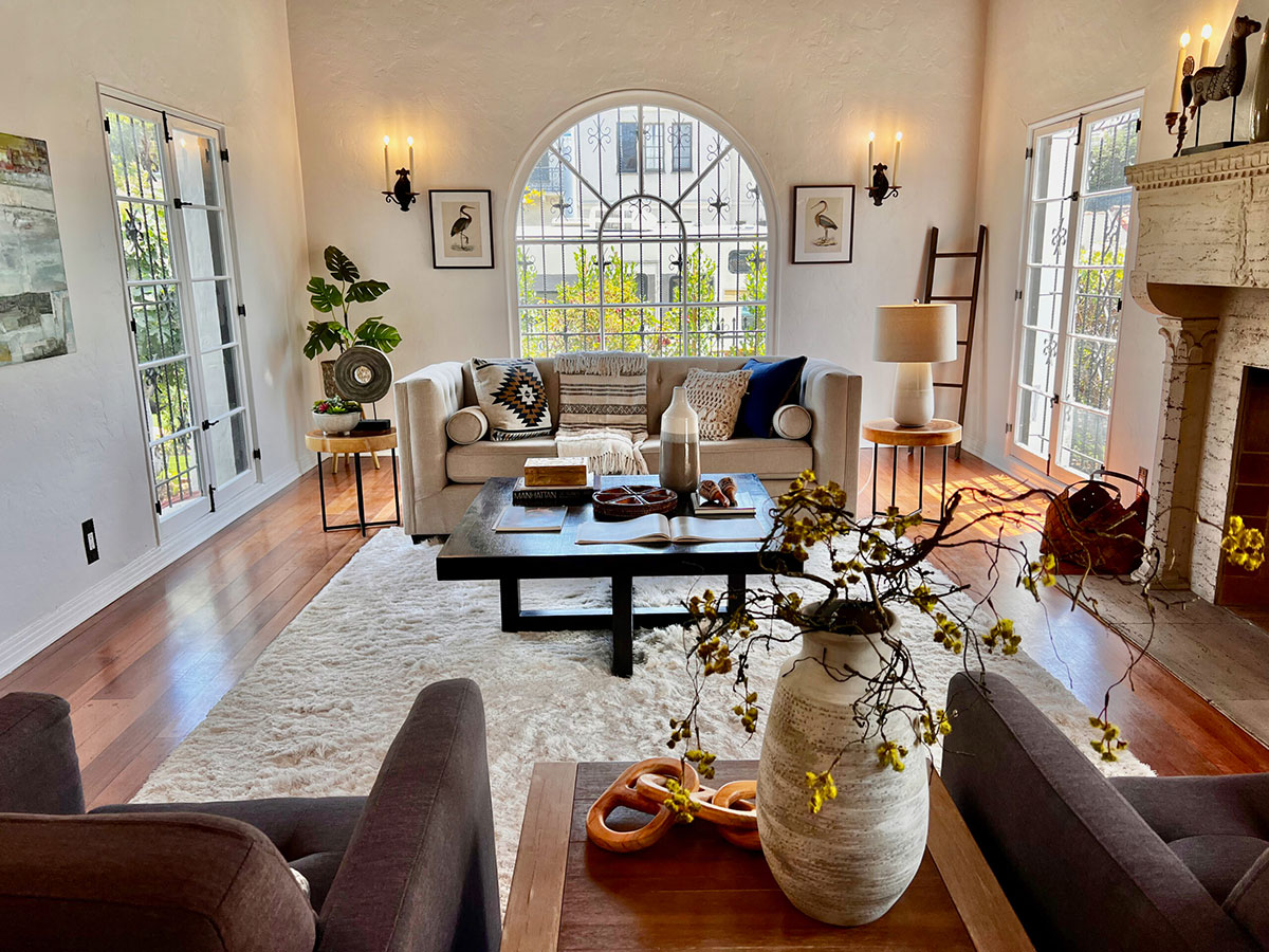 Los Angeles living space with sofa, fireplace and large windows.