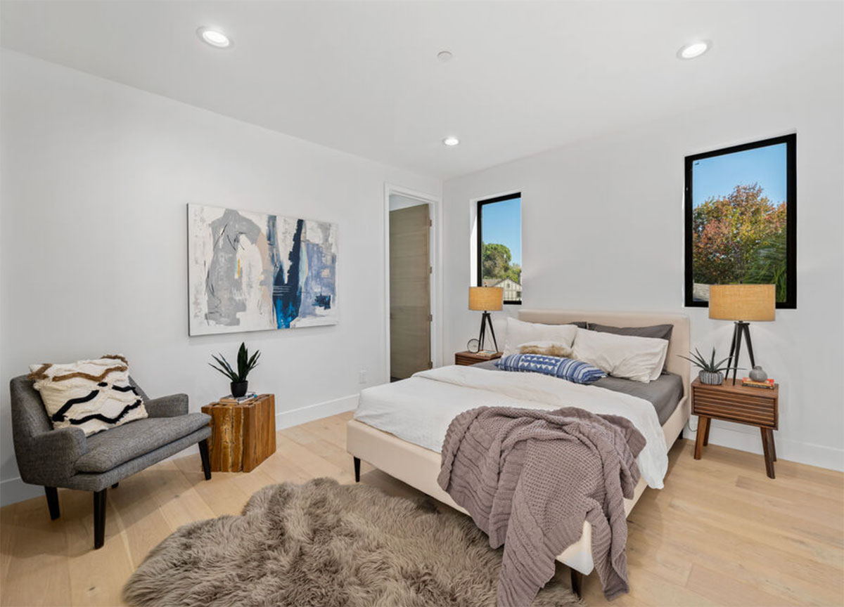 Rustic bedroom with rug, throw blanket and painting in Southern California.