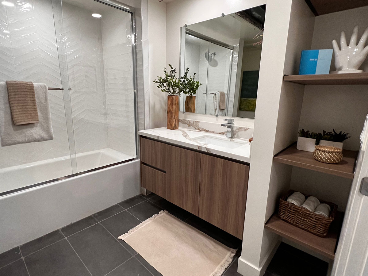 Staged bathroom with bath and shower in glass enclosure.