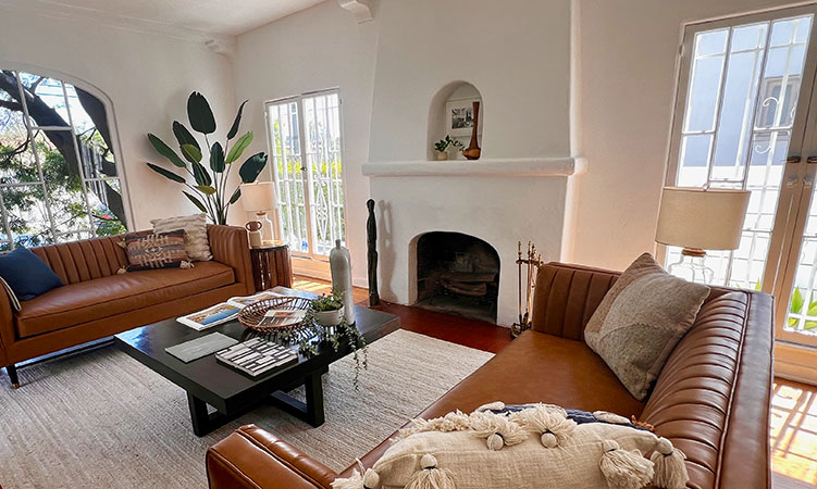 Staged room with sofa, piano and dark wood flooring in California.
